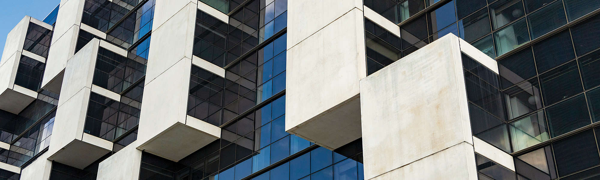 Original white balconies in a glass facade and blue color with straight lines