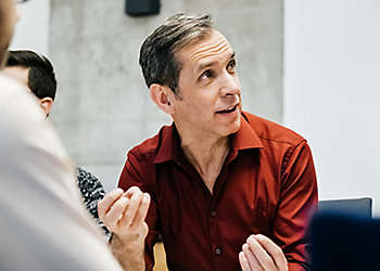 Mature Man Speaking in Meeting