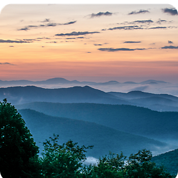 View of mountains covered with mist and vibrant sky