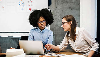 Two young women having a discussion in a business