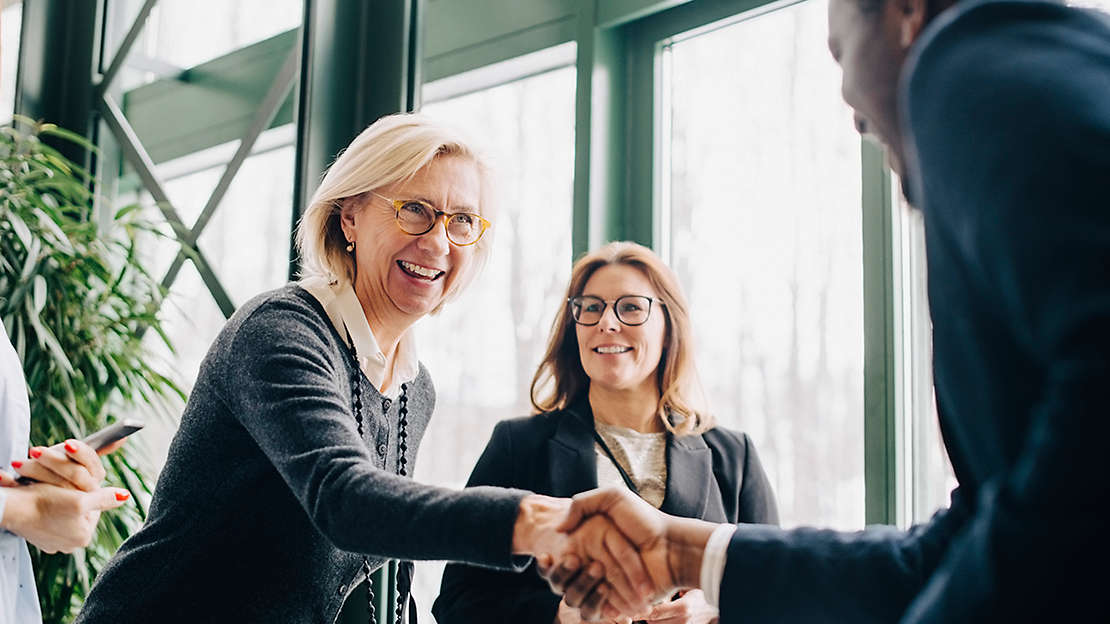 businesswoman shaking hands with colleague