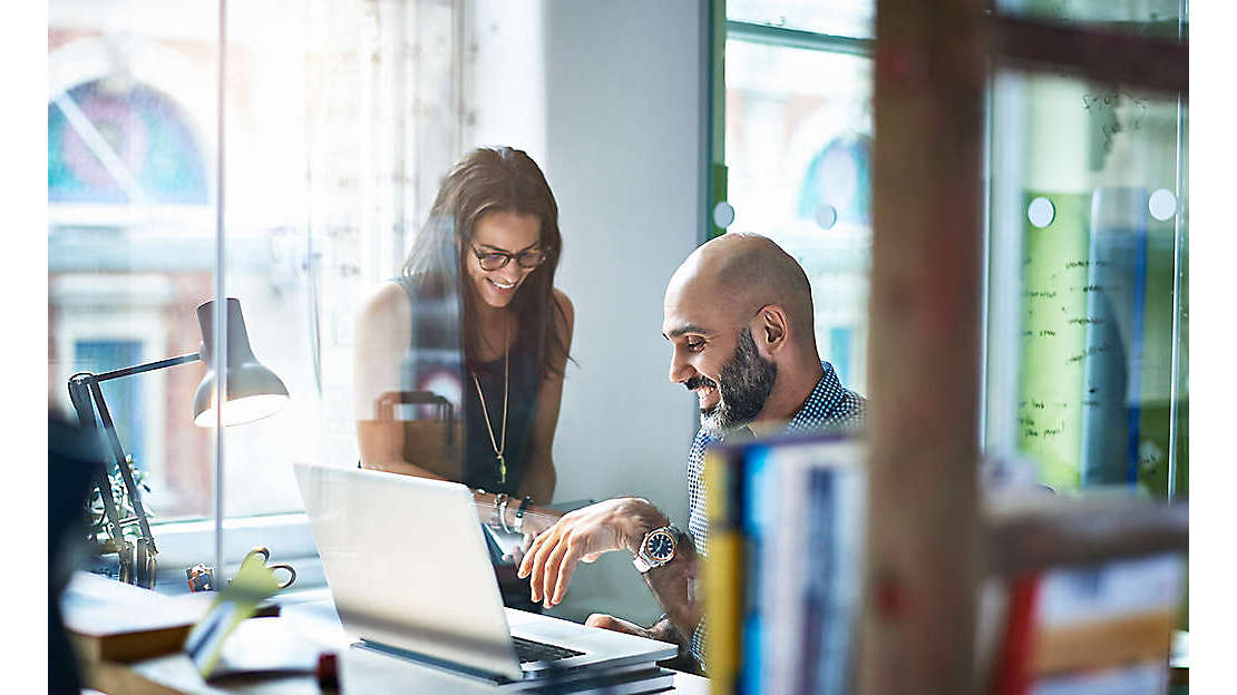 two colleagues reviewing work on laptop